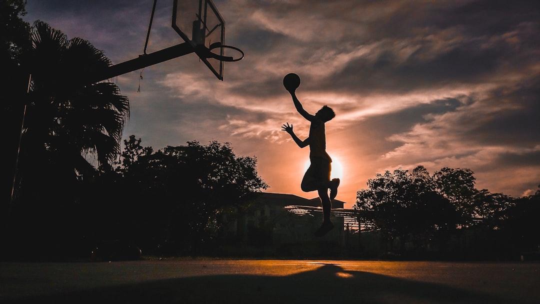 Man jumping towards basketball hoop with a basketball